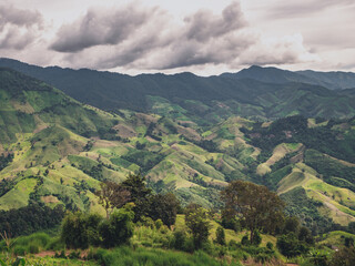 Naklejka premium Beautiful green moutain with valley in rainy day background. Nature and landscape picture from Nan province, Thailand.