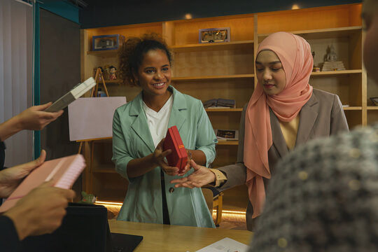 Diverse Businesswomen Having Gift Exchange Activity In Office