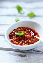 Spicy Tomato, Chilli and Pepper sauce salsa. Bright wooden background. Close up. 