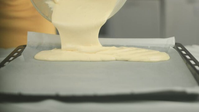 Close up of a cake dough being put on a baking plate with a backing sheet by a vegan chef. Shot in 4K.