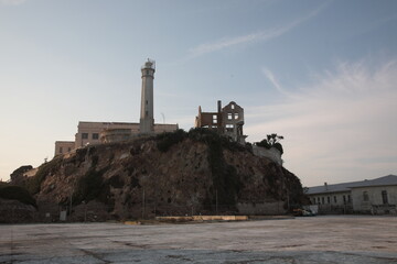 View of Alcatraz Island with prison and lighthouse under sunset in San Francisco, California, USA.