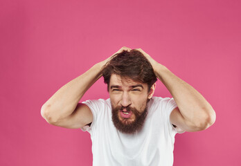 A man on a pink background gestures with his hands Copy Space irritability emotions