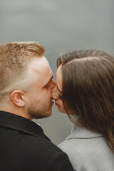 Cute couple in a park. Lady in a gray coat. People on the pier.