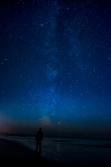 Obraz na płótnie Canvas Adventurous man watching the stars on a beach at night. 
