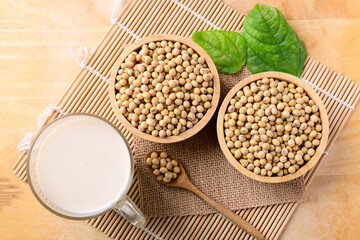 Soy milk in the glass and soy beans on wooden background, Top view