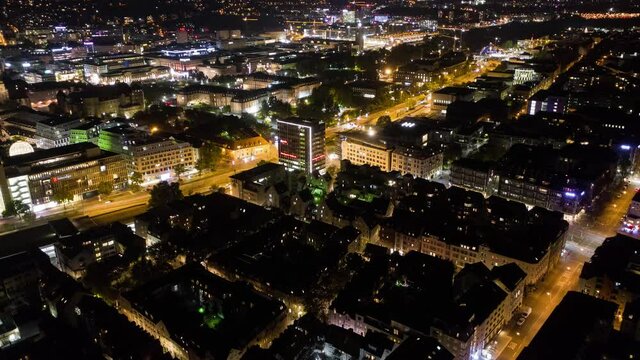 Aerial night time lapse in 4k of downtown city skyline in Stuttgart, Germany  panning down.