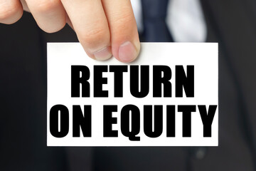 Businessman shows a card with the text RETURN ON EQUITY