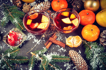 Mulled wine in a glass glass with fruit on a dark background, top view