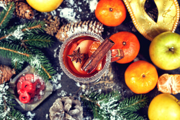 Fototapeta na wymiar Mulled wine in a glass glass with fruit on a dark background, top view