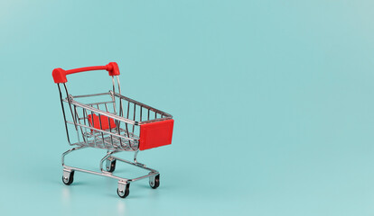empty shopping cart on blue background with copy space.