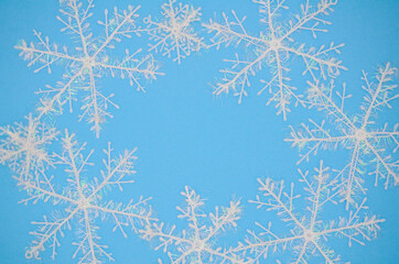 White snowflakes on a blue background. Christmas background. Christmas flat lay.