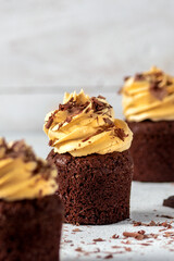 Chocolate cupcakes with pumpkin cream on light background