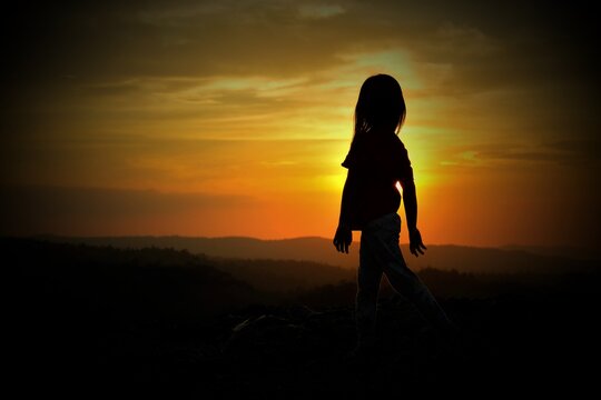 Silhouette photo of a human with a sunset background