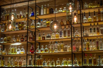 Deurstickers Defocused background of bar counter with various bottles of alcohol. © javarman