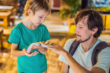 Smiling boy and his father holding python in hands