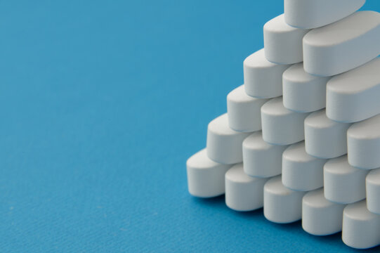 Pharmacy lab and pharmaceutical research concept with white medical pills tablets on blue background with copy space
