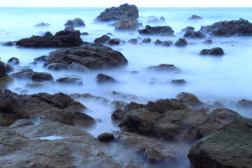 Obraz premium Long exposure capture of rocks, stones, and waves at Pintu Kota beach, Ambon island, Indonesia