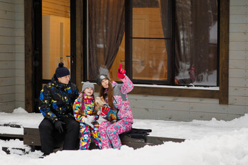 Naklejka premium Family in winter on the porch of the house