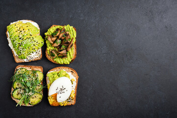 Set of avocado toasts with different toppings. Vegetarian avocado toast with egg, fried mushrooms,...
