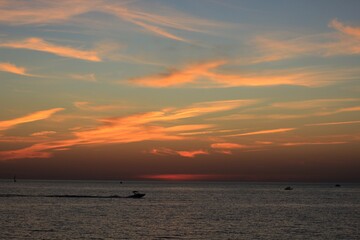 Fototapeta na wymiar a boat sails in the black sea against a beautiful sunset