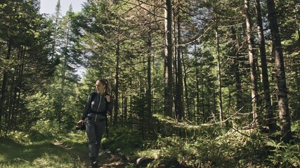 Fototapeta premium Traveler photographing scenic view in forest. One caucasian woman shooting nice magic look. Girl take photo video on dslr mirrorless camera. Professional photographer travel with backpack. Outdoor.