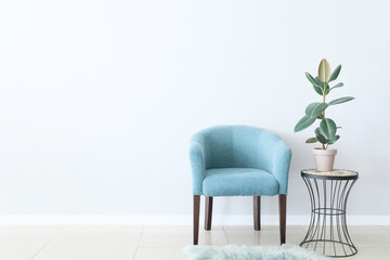 Armchair and table near light wall