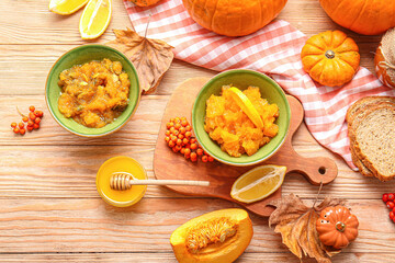 Autumn composition with tasty pumpkin jam on wooden background