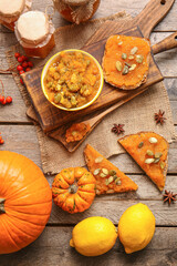 Tasty pumpkin jam with bread on wooden background