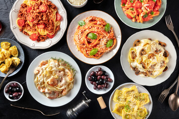 Fototapeta na wymiar Pasta, many different varieties, shot from the top on a black background, Italian food flat lay