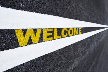 Welcome word written on asphat road. Business beginning concept and keep going idea