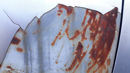 The surface of the car body paint that is cracked and peeled, causing many red rust spots