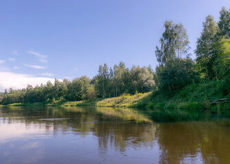 Fototapeta na wymiar beautiful morning on the river, shore and tree reflections in the water, Gauja river, Latvia