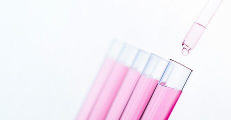 five tubes in a row and a drop of liquid from a pipette