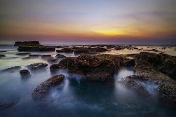 Amazing seascape. Landscape background. Beach with rocks and stones. Low tide. Motion water. Slow shutter speed. Soft focus. Mengening beach, Bali, Indonesia