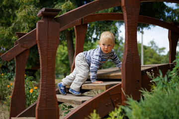 little child playing on a wooden ladder