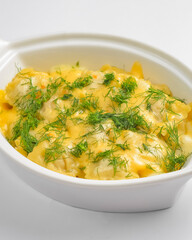 Ravioli dumpling with fresh greenery served in a white pot over white background. Isolated on white.