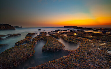 Amazing seascape. Landscape background. Beach with rocks and stones. Low tide. Motion water. Slow shutter speed. Soft focus. Mengening beach, Bali, Indonesia