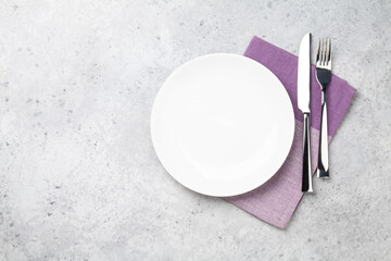 White empty plate, fork, knife and napkin