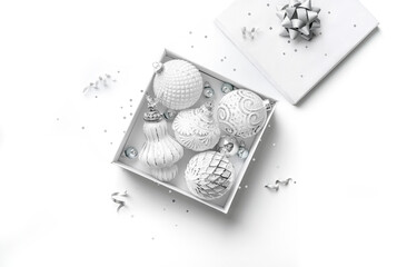 Merry Christmas card made of gift box, white and silver decorations, fir branches, sparkles and confetti on white background. Xmas and New Year holiday, bokeh, light. Flat lay, top view