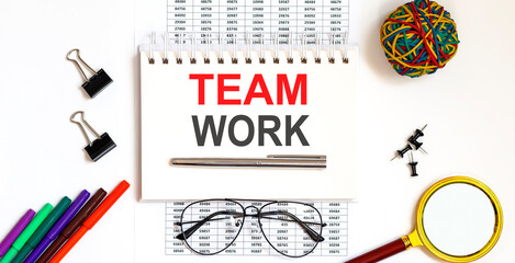 TEAM WORK inscription text on white notepad on office table.