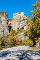 Road passing through meteora and varaam monastery as background , an unesco world heritage site,  located on a unique rock formation  above the village of Kalambaka.