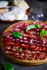 The cut salami sausage on a chopping board