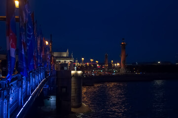 Fototapeta na wymiar Illuminated bridge over the river at night. Blurry background photo. View of Saint Petersburg.