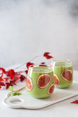 Matcha green tea breakfast superfoods smoothie with figs in glasses. Side view, copy space. Japanese matcha tea drink, dessert. Healthy superfoods, detox, diet