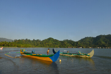 Fototapeta premium Indonesian fisherman on his outrigger boat at Kiluan Bay.