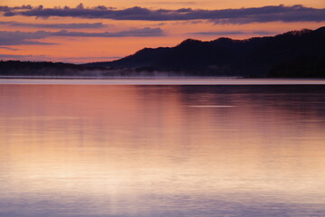 静寂の湖と稜線のシルエット。屈斜路湖、北海道、日本。