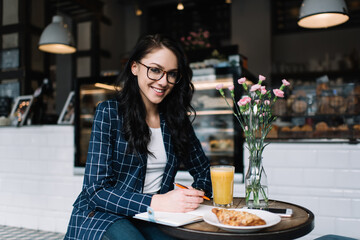 Joyful female worker sitting in cafe during work break