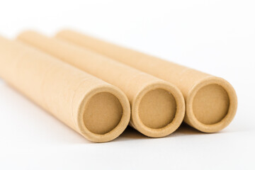 Empty brown cardboard roll tube on white background.