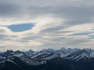 Panorama-Blick über die schneebedeckten Alpen in Tirol in Österreich bei guter Fernsicht und leicht bewölktem Himmel