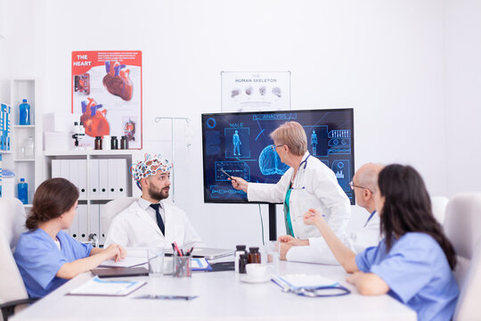 Brainwave electroencephalograph examination in hospital by medical physician. Monitor shows modern brain study while team of scientist adjusts the device.